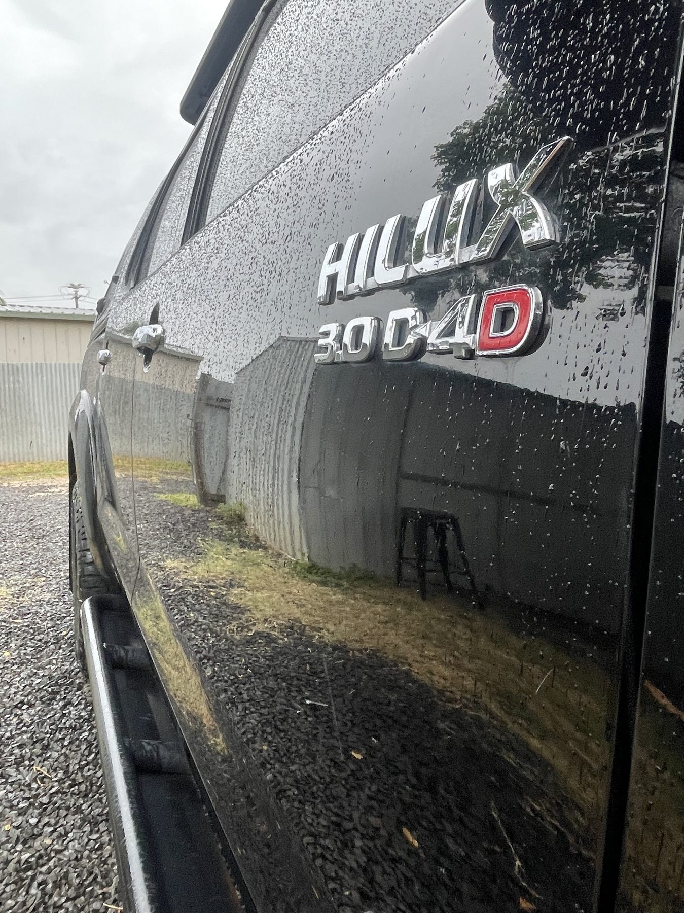 Water beading on the freshly polished flank of a black Toyota HiLux